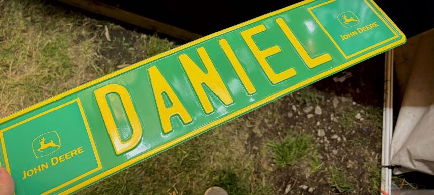 DANIEL — zelená tabuľka John Deere so žltým razeným písmom a logom