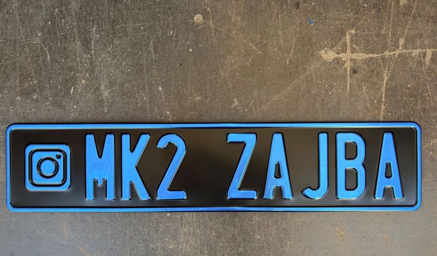MK2 ZAJBA — čierna tabuľka s modrým razeným písmom a ikonou Instagramu